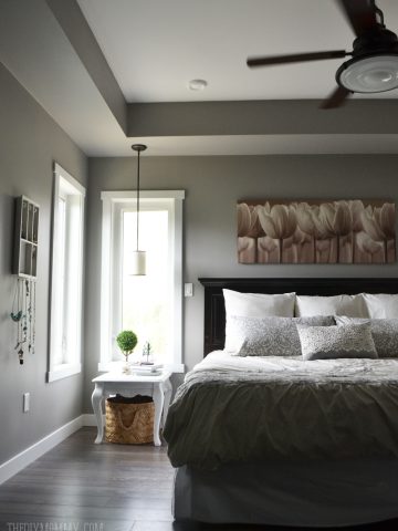 A serene grey and white master bedroom with DIY pillows.