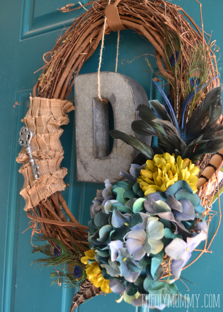 A vintage inspired teal Fall wreath with burlap, feathers, hydrangeas, and a monogram.