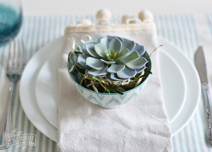 A simple potted succulent is placed on a plate beautiful nature inspired table setting idea.
