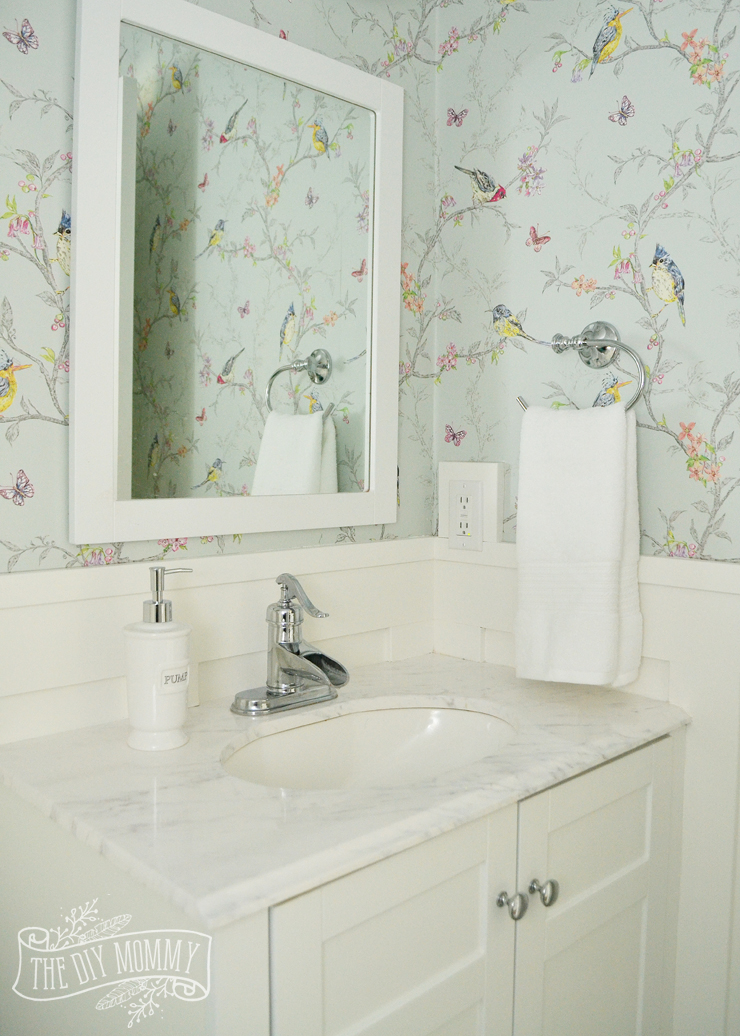Un relooking de salle d'eau bricolage avec un papier peint oiseau et floral inspiré de la chinoiserie et une garniture de planche et de latte