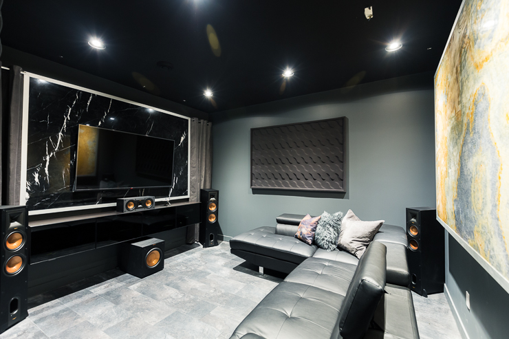 An ultra modern theater room / movie room / man cave design with marble panel artwork in black, grey and rust orange