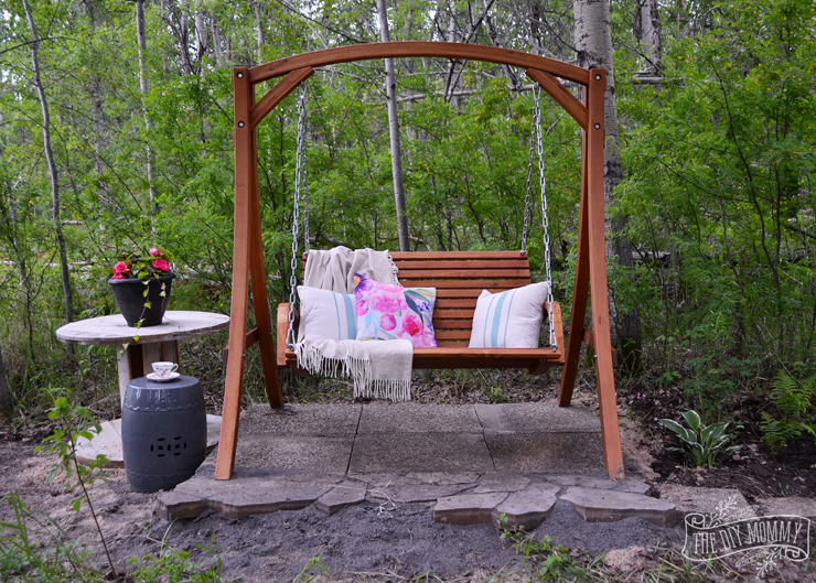 A secret garden swing retreat - the perfect little mini patio in the woods with a shade garden, a wooden swing, and a side table for drinks
