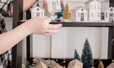 DIY Christmas Advent Calendar featuring handmade paper houses on a shelf