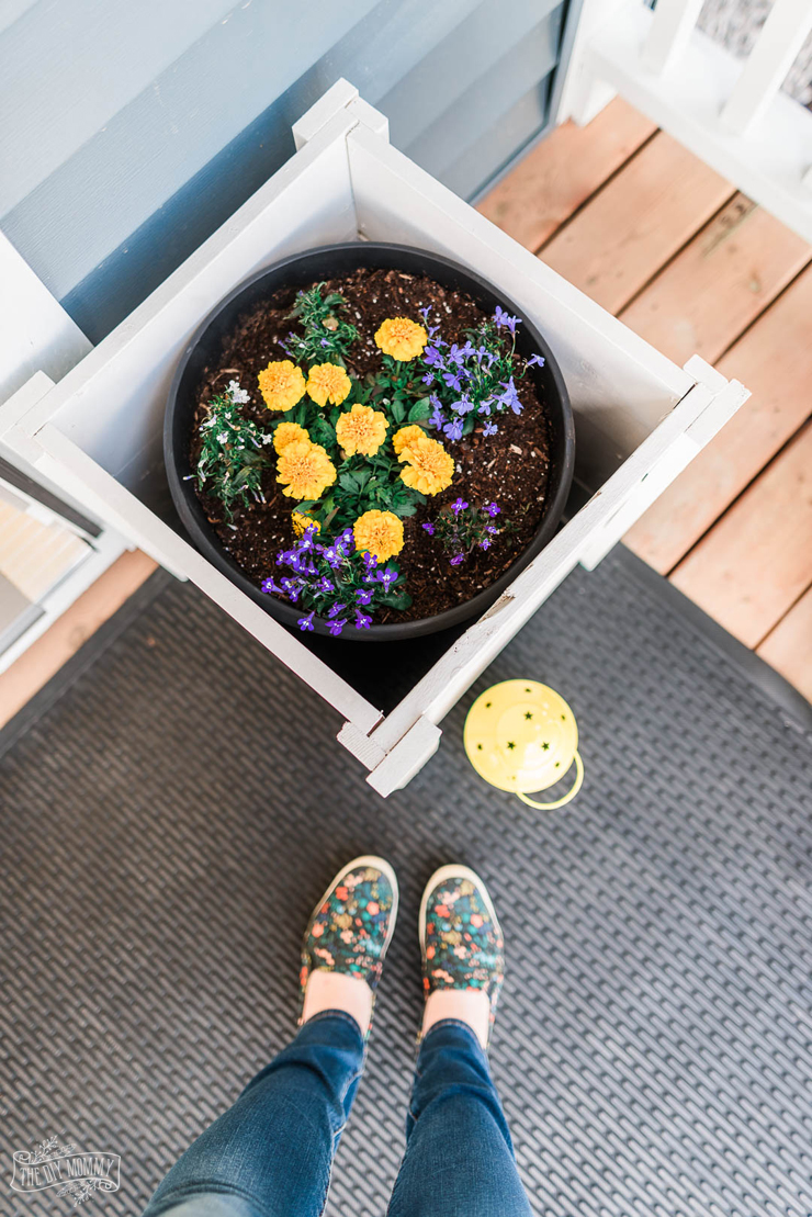 This front porch makeover with DIY outdoor chairs features bright yellow accents and handmade planter boxes. Get ideas for small front porch decorating!