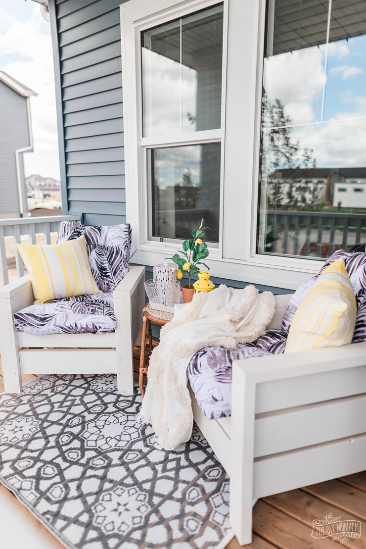 Cette métamorphose du porche avec des chaises d'extérieur bricolage présente des accents jaune vif et des jardinières faites à la main.  Obtenez des idées pour la décoration d'un petit porche!
