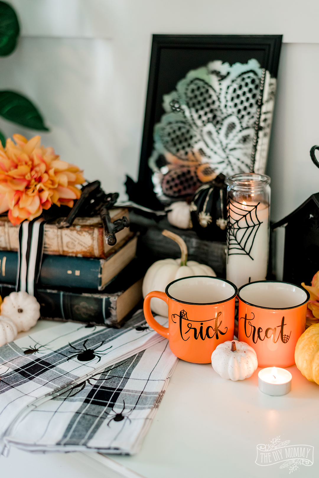 Indoor DIY Halloween decorations with Cricut and Dollar Store decor Ideas including orange cups, napkins and a spooky candle