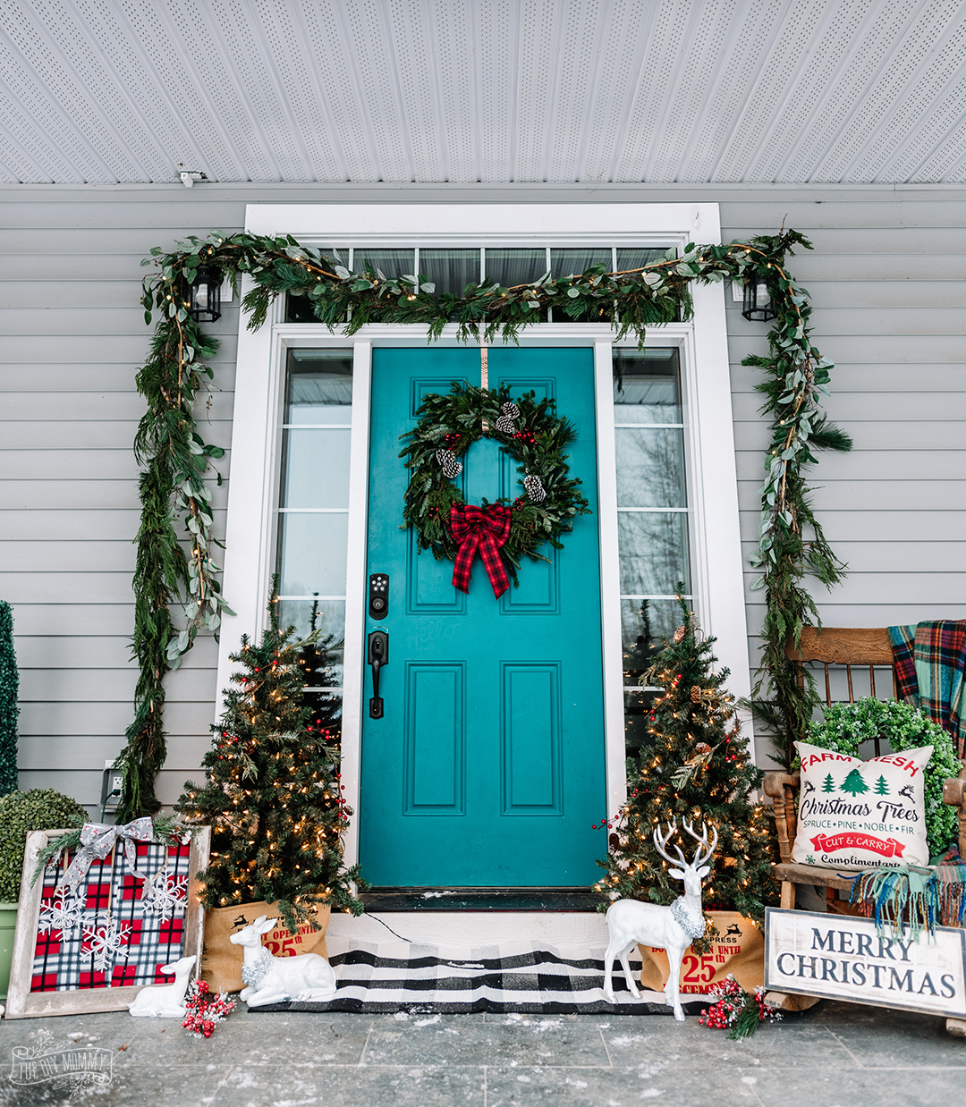Christmas front porch in traditional farmhouse decor in reds, greens and teal colors