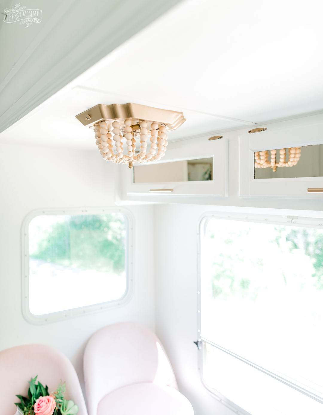 See how I transformed a flush mount fixture in our camper into a beautiful wood bead chandelier with this ceiling light DIY $7 boho makeover!