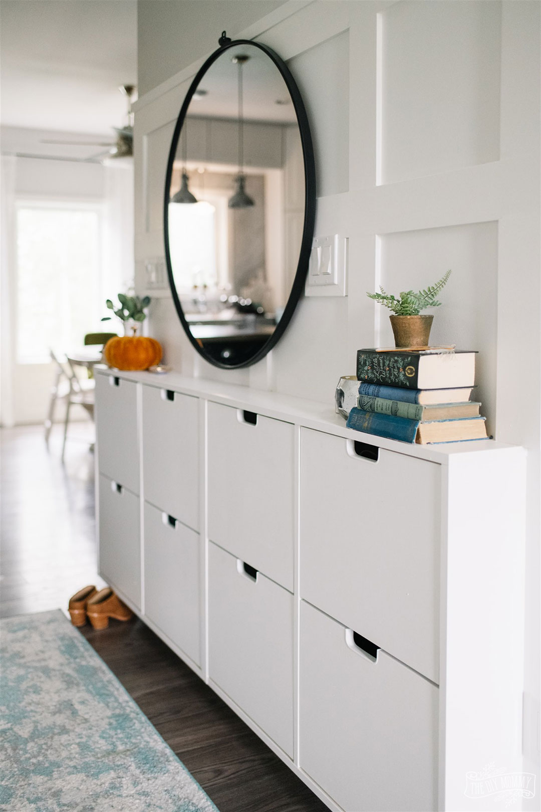 White entry with IKEA shoe cabinet hack and large round mirror decorated for Fall