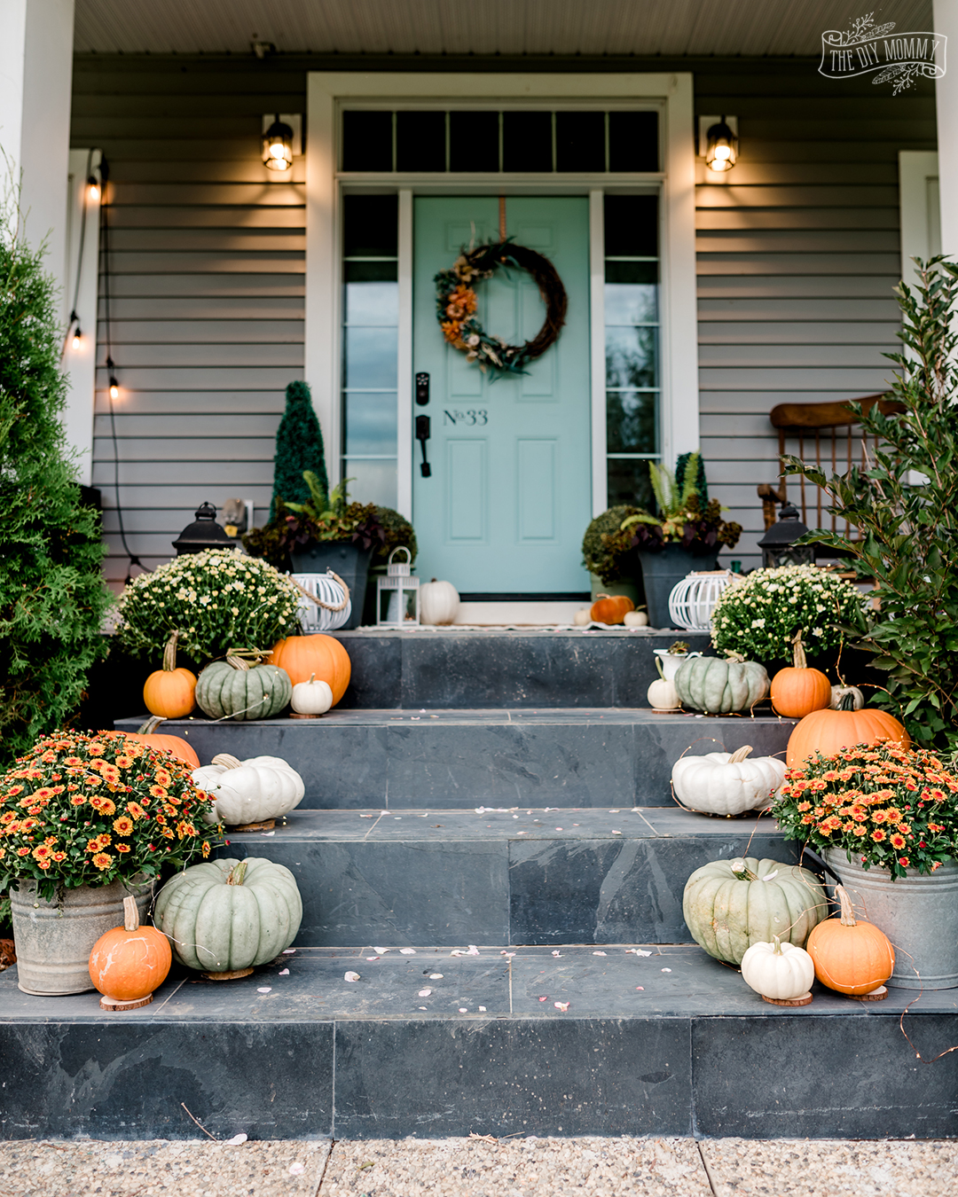 Beautiful Fall porch with pumpkins, mums, soft orange and aqua blue green.