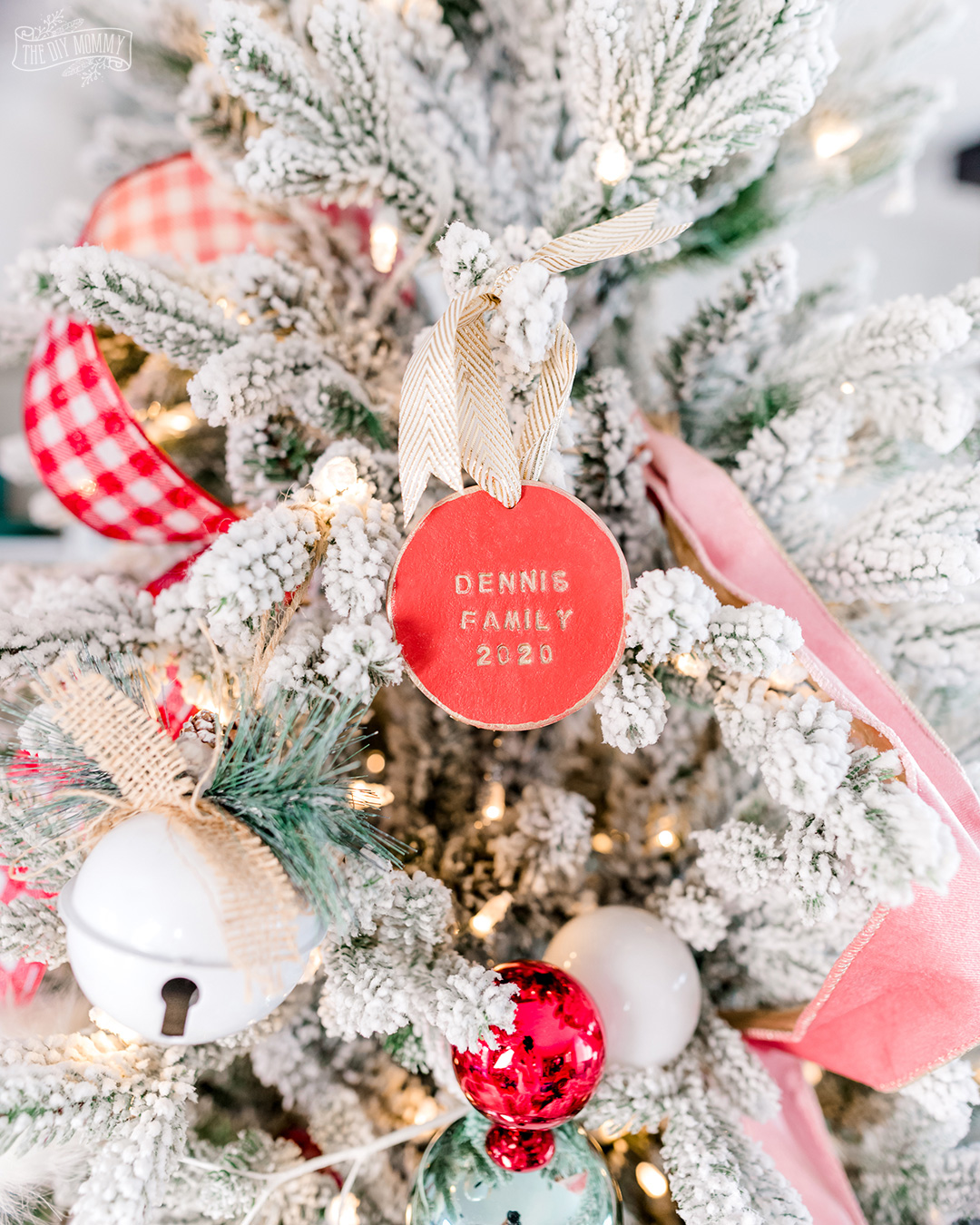 DIY Stamped Christmas Ornament made with Clay hanging on a Christmas tree. You can easily personalize these for all the teachers on your list