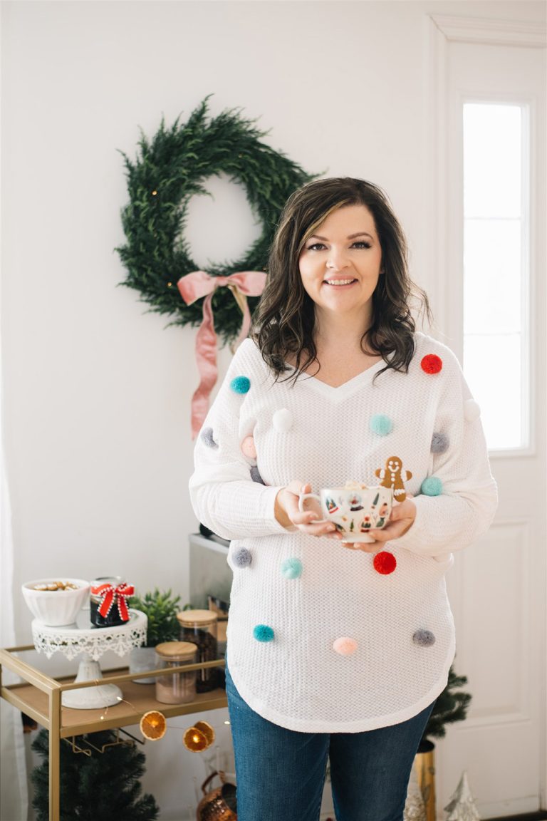 Make an easy DIY ugly Christmas sweater with a white v-neck sweater, pom-poms and hot glue.