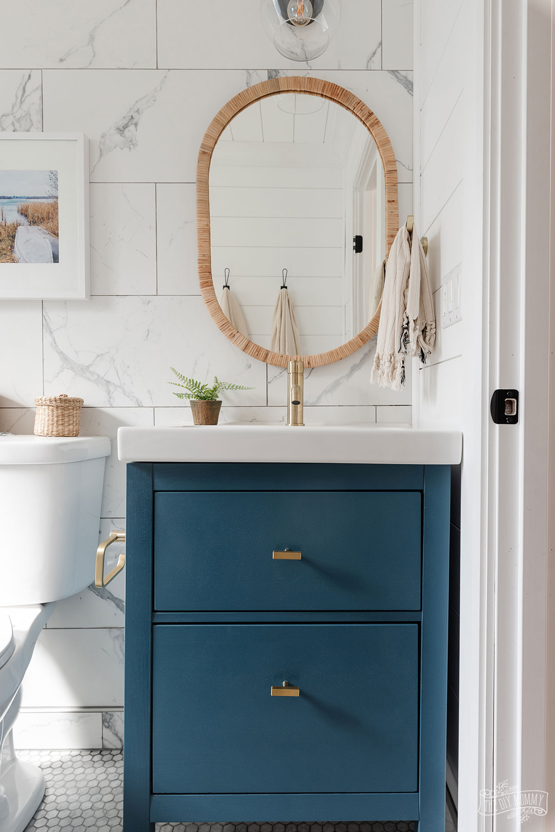 An IKEA bathroom cabinet is painted blue for a modern coastal look.