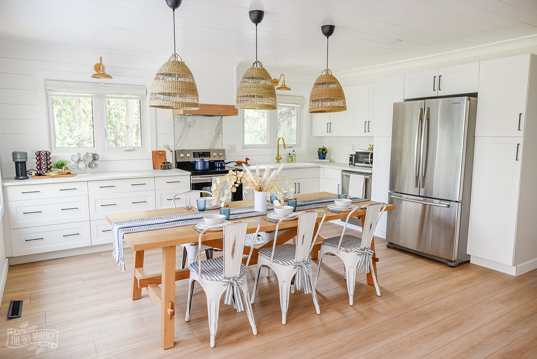 See how a dated honey oak kitchen was transformed into a coastal modern farmhouse kitchen with an eat-in layout, white shaker cabinets and white oak accents.