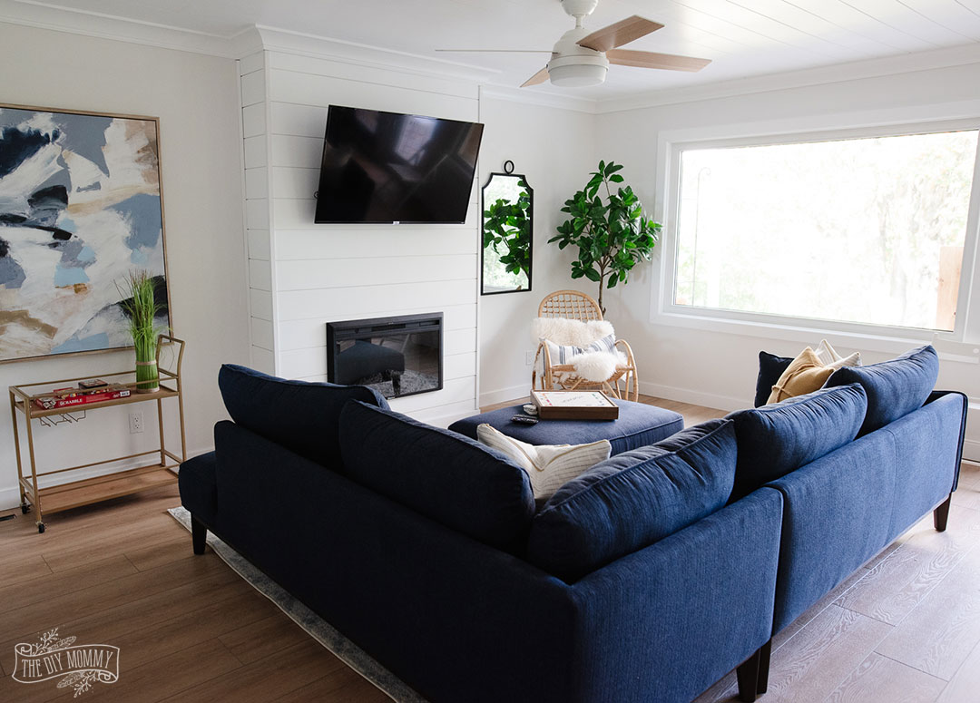See how a boring, dated living room was transformed into a coastal modern farmhouse space with a DIY shiplap fireplace and adorable office nook with storage.