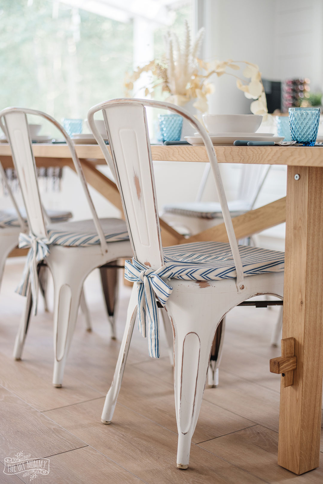 Need to make your metal farmhouse bistro chairs comfier? Learn how to sew these simple DIY chair pads with adorable bow ties at the back! These are an easy beginner's sewing project and you can make them to match any decor style.