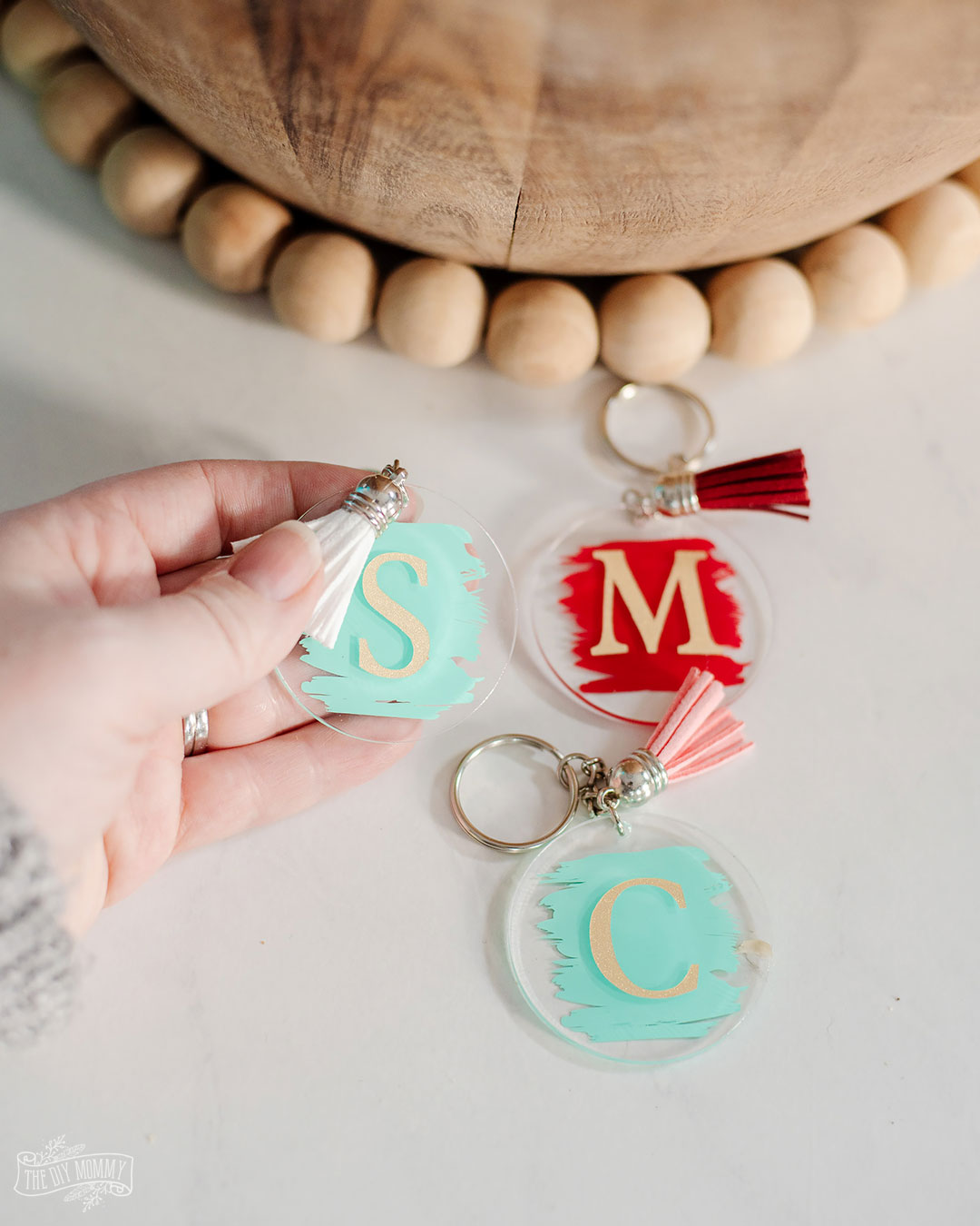 3 DIY personalized acrylic keychains in turquoise and red each with their own tassel. 