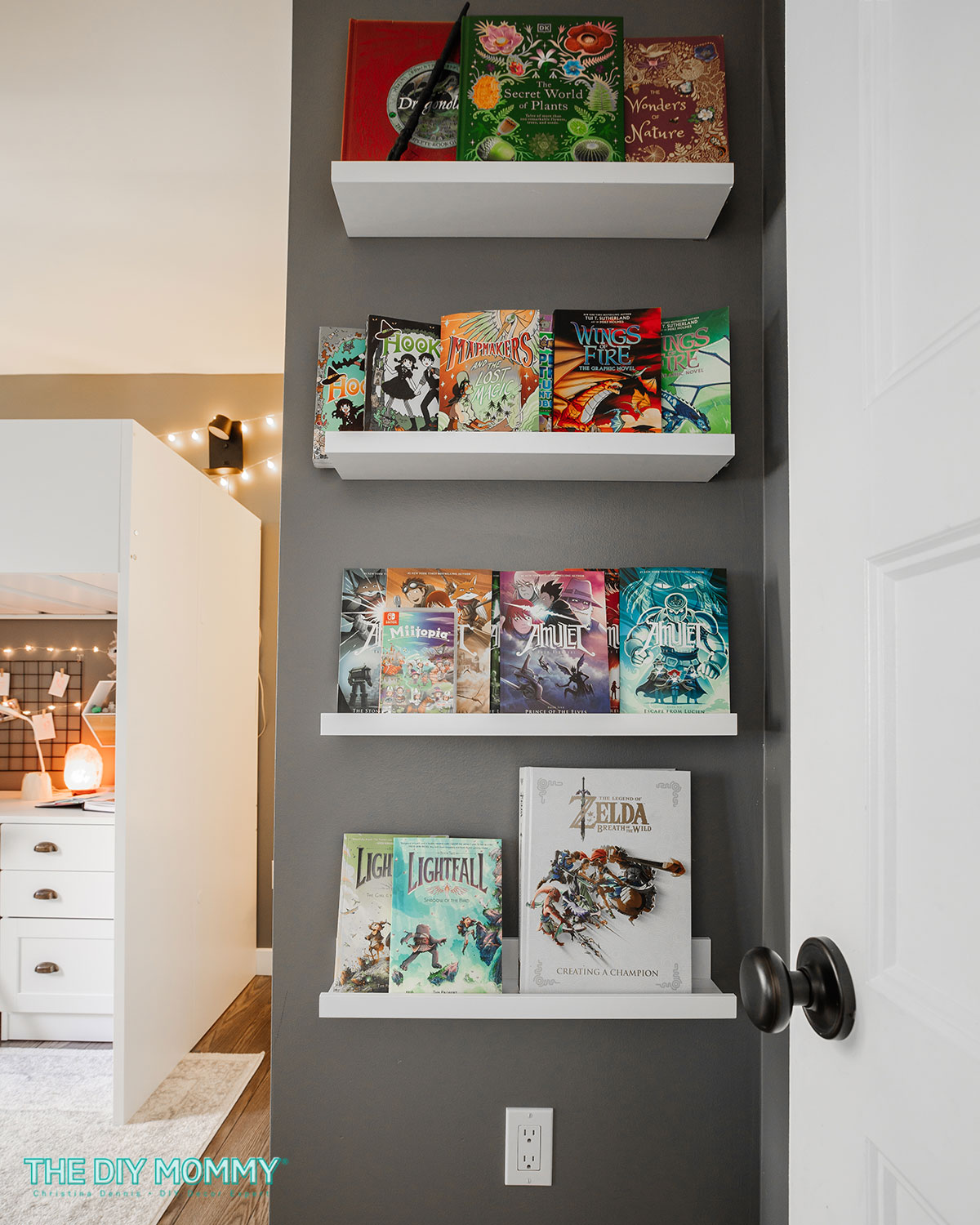 A small bedroom wall painted grey with white floating shelves for books.