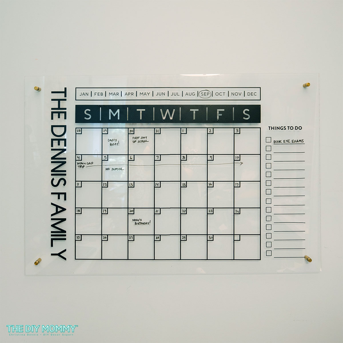 A large family wall calendar made using a Cricut Maker 3, black vinyl, and a large piece of acrylic.  